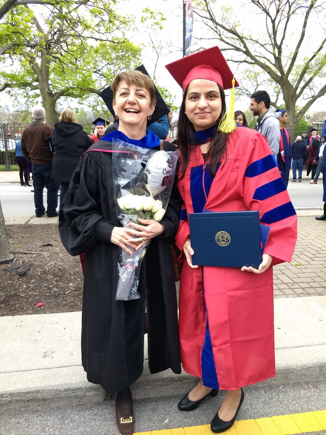 Professor Di Eugenio, who is holding flowers, standing next to Sabita, who is holding her diploma